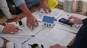 Close up of hands working brainstorming and measuring for cost estimating on paperworks and floor plan drawings about design architectural and engineering for houses and buildings.
