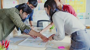 Meeting of UX developer and UI designer brainstorming about mobile app interface workflow design on a table with coworker brief and color code at co-working space.Creative digital development agency.