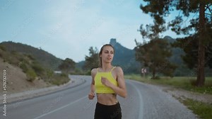 slow motion portrait of Young Athlete Woman Running Fast down Road, Training Hard, Getting Ready for Race Competition or Marathon. Fit Girl in Black shorts Jogging At Dawn along Green Fields.