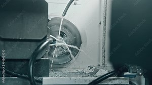 High-speed cnc machine precisely cutting a metal cylinder with coolant spray to reduce heat and friction. Professional manufacturing process in action