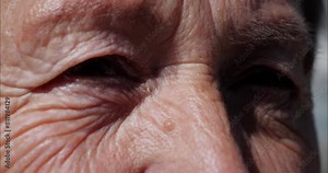 The face of an old man. Aged skin with wrinkles. Eyes and a wise look. The pensioner thought. Care for mature skin.