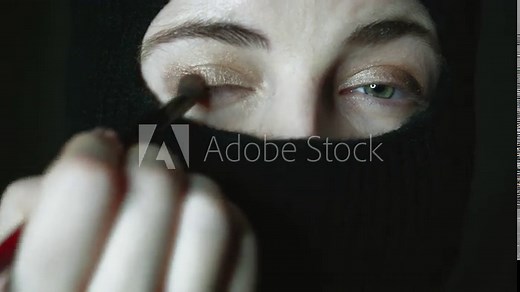 Muslim makeup step by step tutorial. A girl with beautiful eyes in a hijab does makeup. Close-up portrait of a charming Muslim woman in make-up.