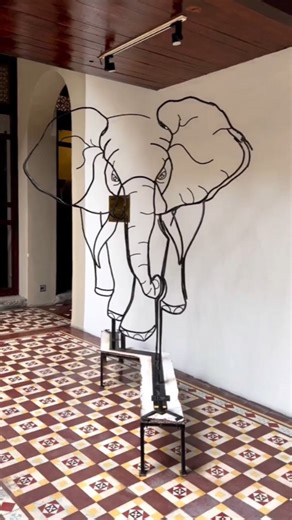 Art Viral 🎨 on Instagram: "Matthieu Robert-Ortis, a French sculptor, is celebrated for his mesmerizing anamorphic wire sculptures that change and evolve based on the viewer's position. One of his most iconic works, *The Revolution of Giraffes*, transforms from two giraffes into an elephant as the viewer moves around it. His pieces delve into the idea of perspective, creating optical illusions that challenge the limits of conventional sculpture. This piece is showcased in the outdoor courtyard o