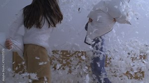 Children Pillow Fight with Feathers Flying, Captured in Super Slow Motion at 1000 fps. Little sister and brother engaged in carefree activity together