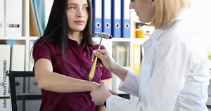 Doctor checks nerve reflexes with hammer on patient hand. Neurological examination technique concept