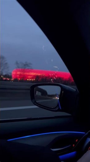 Allianz Arena leuchtet rot Abendfahrt auf der A99 München