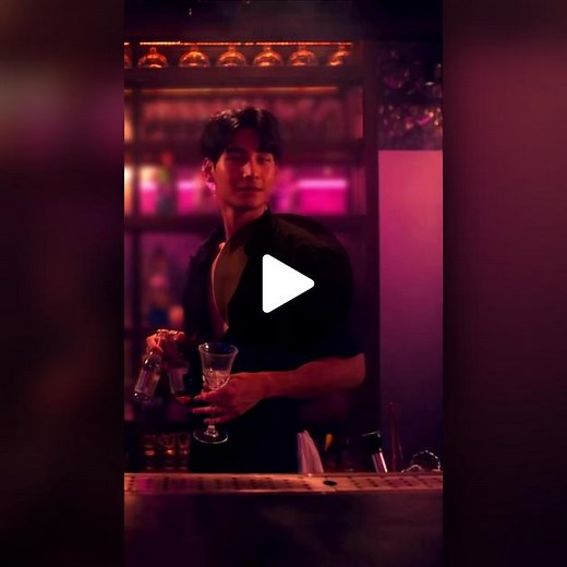 Bartender Mixing Drinks in a Lively Bar Atmosphere