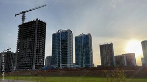 Construction site with buildings under construction. Tower cranes in action. Crane during formworks of house. Multi Storey Residential Buildings construction. Tower crane on Housing renovation.