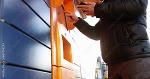 Man enters parcel code on screen and picks up parcel from post office. Receiving in parcel machine concept