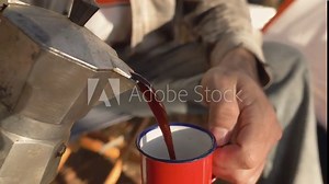 Man making coffee with stove and italian coffee maker at camp