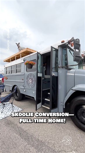 What do you think of this school bus conversion that is a full-time home on the road? Would you live & travel in this skoolie? Inside, there is a cozy living space with a built-in couch; a kitchen with a 3-burner gas cooktop, an air fryer, a sink, convection oven, a fridge, & tons of storage; a bedroom with a queen bed; a wet bathroom with a shower & toilet (not shown); & best of all—a rooftop deck! #tinyhouse #tinyhome #skoolie #schoolbus #vanlife | Dream Big Live Tiny Co.
