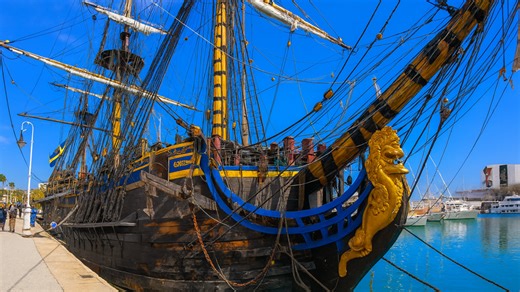 Walking past a historic wooden sailing ship