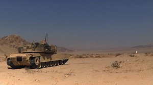 clip-26629606-m1a1-tank-firing-across-desert-terrain