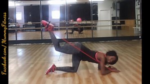 The donkey kick exercise using a resistance band for an increased...