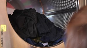 Woman loads the laundry in the washing machine