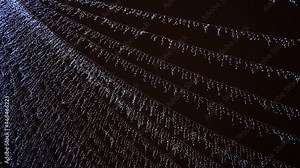 Led outdoor icicle lights are swinging on dark celebration sky, shiny Christmas street illumination.