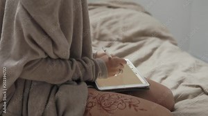close up shot of woman hands, lady draws art objects on a portable tablet using a pencil, on her leg is a mandala made with henna, buta is a guardian Stock Video