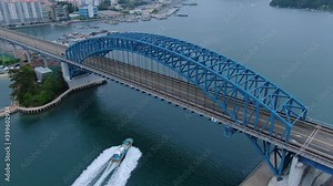 a fishing boat passing under a bridge at high speed.