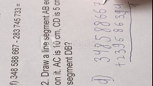 child, right-handed schoolchild hesitantly solves difficult task of adding numbers, 5th grade student writes down numbers in notebook with pen, education concept, development of mathematical abilities