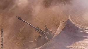 Aerial of soldiers firing heavy artillery in the battlefield.