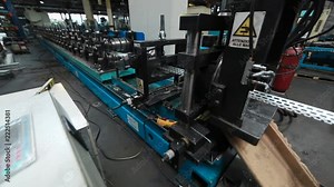 Profiles are created on the metal rolling machine at the plant. creation of profiles, machine for creation of steel profiles from steel sheet. close-up