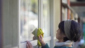 Image of a woman cleaning windows