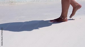Beautiful woman legs, walking along the beach. Leaving footprints on sand