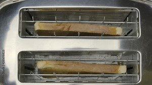 Top view of burnt bread popping out of a toaster. Close-up. Fire hazard concept.