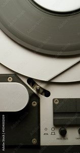 Sound recording on a tape recorder in a recording studio. Fast movement of the magnetic tape, close-up