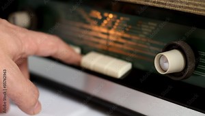 Hand turning on an old radio tuner