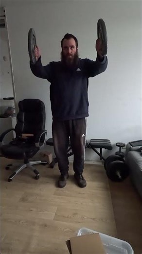 Doing front raises with 5KG weight plates