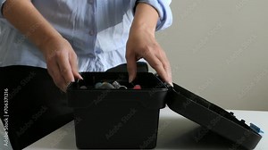 Woman opening toolbox and picking up small spanner