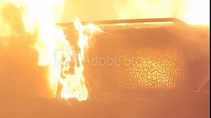 Closeup of a burning car with big fire, window breaks and flames get bigger in slow motion. Car accident. High quality 4k footage