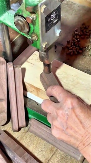 Buffing wooden knife handles with rotating wheel.