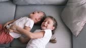 La sorella solletica il fratello mentre è sdraiata sul divano. I...