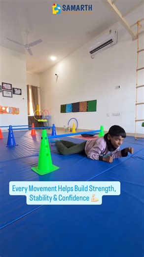 Samarth Assisted Living on Instagram: "Crossing hurdles using a commando crawl builds whole-body strength while improving coordination and body control. Picking up the ball while lying on the mat and then sitting to place it in the box activates the core muscles and enhances postural stability. Climbing the ladder supports motor planning, balance, and sequencing skills. Weight bearing on the plank strengthens the shoulders and provides deep pressure input through the hands, improving upper-body 