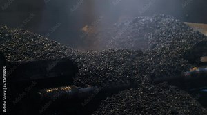 Close-up of fresh asphalt mix. An asphalt paver is laying asphalt. Steam from hot asphalt mix. Road repair, new road construction.