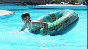Happy Boy Having Fun in the Swimming Pool On Float Inner Tube Ring. Summer Vacation Fun. Enjoying sun vacation Stock Video