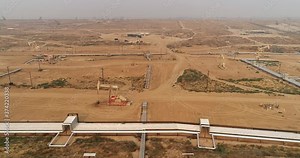 Vast oil fields in California. Pipelines transporting oil from oil pumps, aerial drone shot