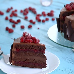 Chocolate Raspberry Cake - moist chocolate cake filled with raspberries and chocolate ganache, frosted with whipped ganache and decorated with fresh raspberries and chocolate shards. Full recipe: https://bit.ly/3GABWvU #chocolateraspberrycake #chocolatecake | Home Cooking Adventure