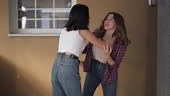 Two aggressive teenage girls fighting outdoors pushing hitting each...