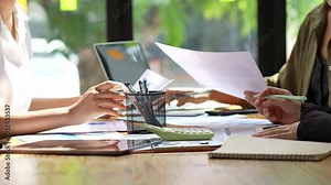 Collaborative workspace showcasing teamwork and productivity, with hands engaged in discussion over documents and tools on table, enhancing office collaboration and effective meetings.