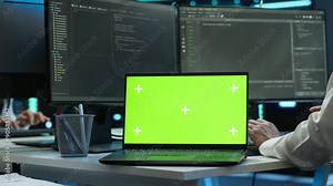 System administrator in data center installing software on isolated screen laptop, troubleshooting issues. Admin uses mockup notebook in server hub, establishing performance benchmarks, camera A