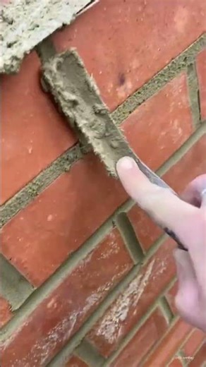 the process of leveling the surface of the side of a brick building