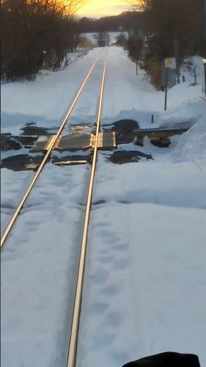 真っ赤な夕焼けに向って雪で真っ白な北上山地の山岳区間の線路軌道を走行する山田線上りキハ110系の前面展望