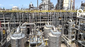 Panorama inside of the interior of a chemical plant or oil refinery. Pipeline structure, heavy equipment in process area. Steel tanks and boilers with cables, pipelines and valves for chemical mixing