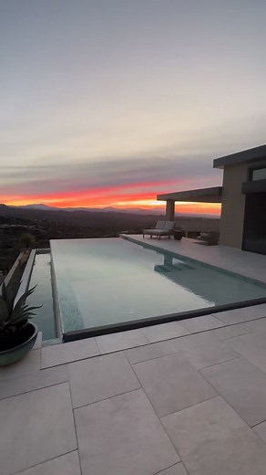 Morning sunrise views from our #netzero build. As you watch throughout the entire video, you will notice the sunken rear patio. This covered patio features a beautiful fireplace and seating area. And of course, the hung TV. The perfect place to start your day or finish your evening. | AFT Construction