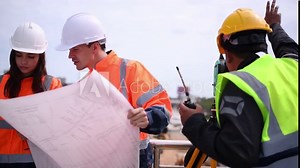 Surveyor engineers wearing safety uniform ,helmet and radio communication with equipment theodolite to measurement positioning on the construction site of the road with construct machinery background.