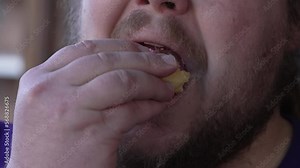One fat guy eating last piece of doughnut donut. Closeup mouth chewing junk food