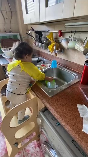 How adorable is this little one using their learning tower to wash the dishes? 殺梁 practical life skills learnt early on thanks to a simple tool! Order yours now  | Eftekassat - Montessori Inspired Furniture Egypt | Facebook